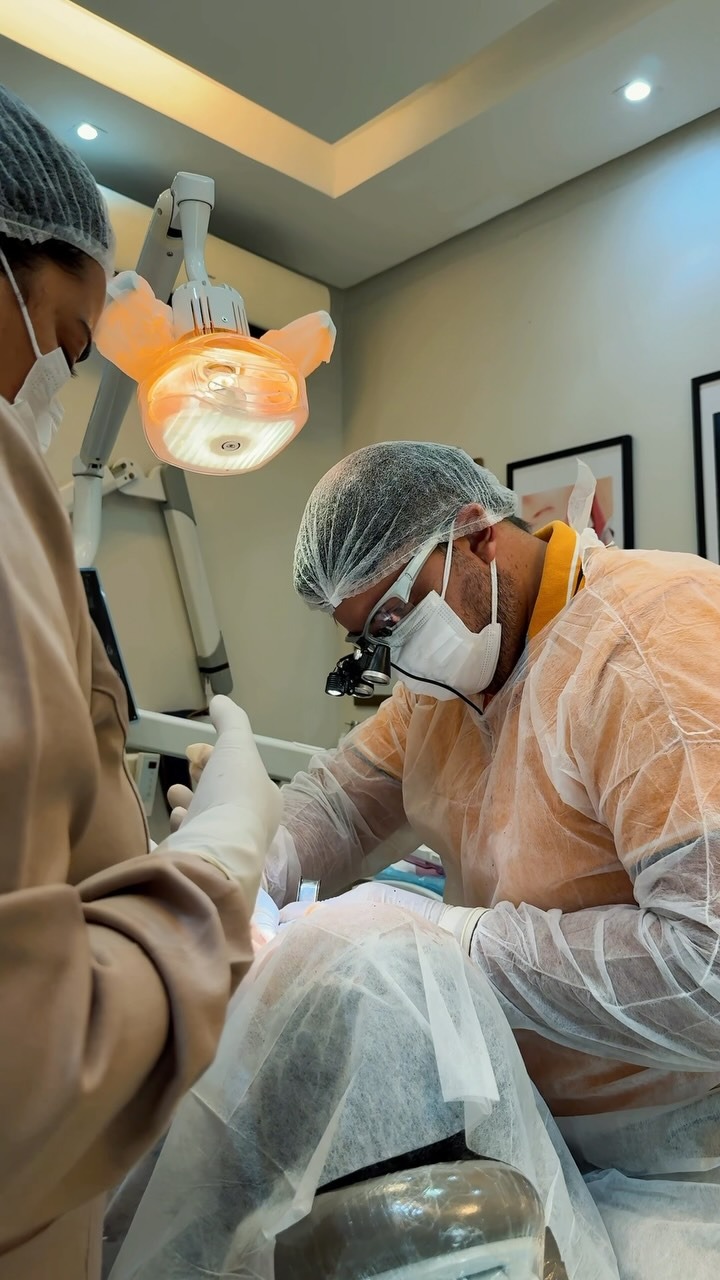 Dr. João Perantoni performing a dental implant procedure in a modern clinic in Pernambuco, Brazil