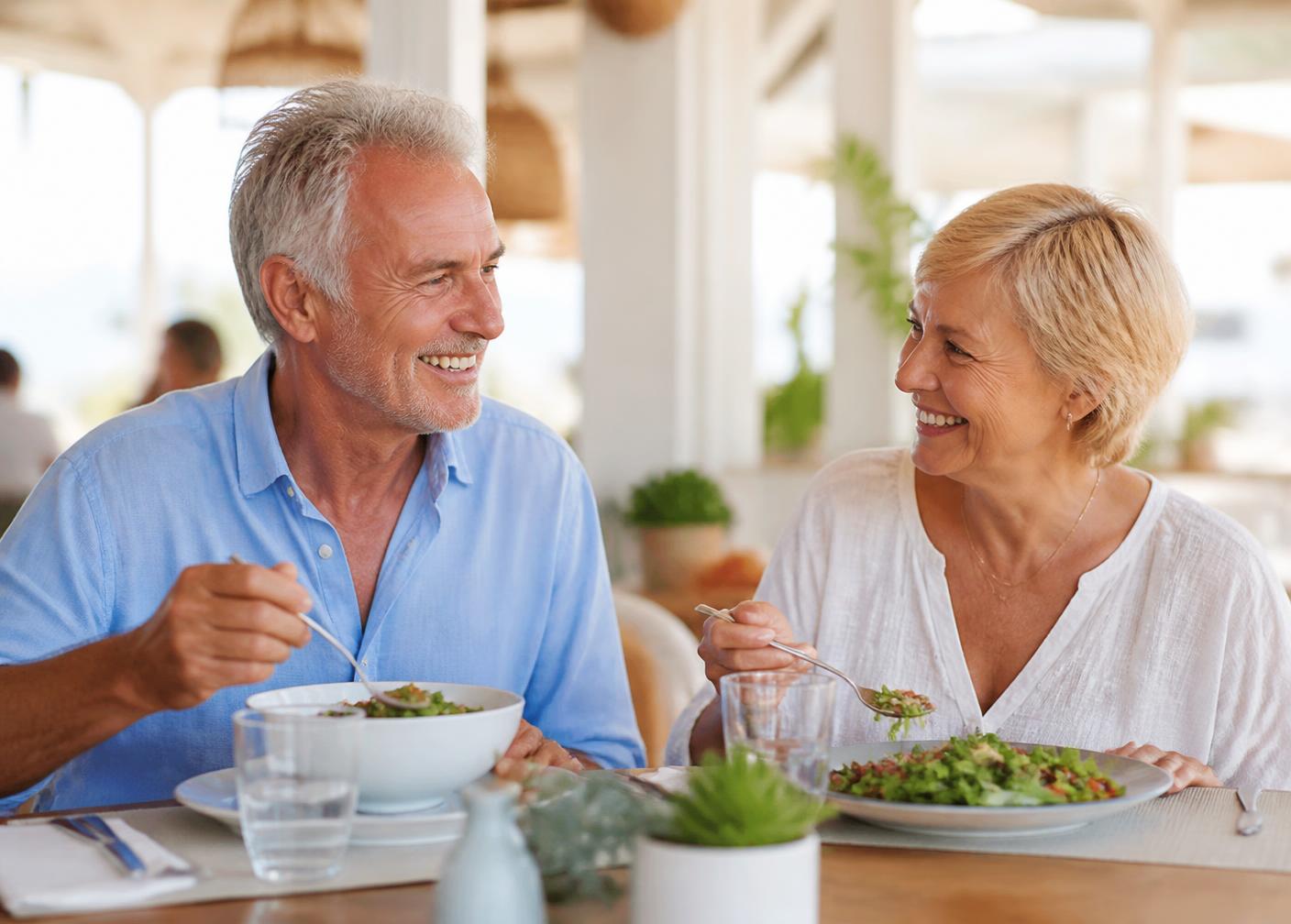 Mature couple eating comfortably and smiling together